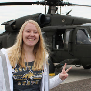 Jeanine Schoessler standing in front of a helicopter